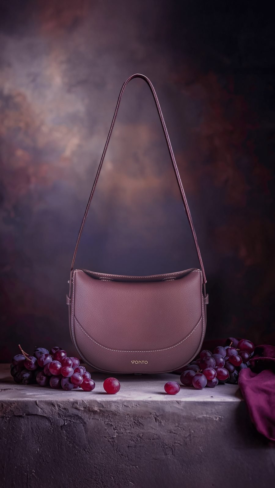 Vonto: Ella in burgundy: the bag on a stone ledge with dark grapes